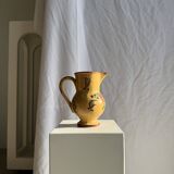 Large antique handmade ochre yellow jug with a pink flower pattern.