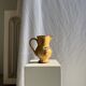 Large antique handmade ochre yellow jug with a pink flower pattern.