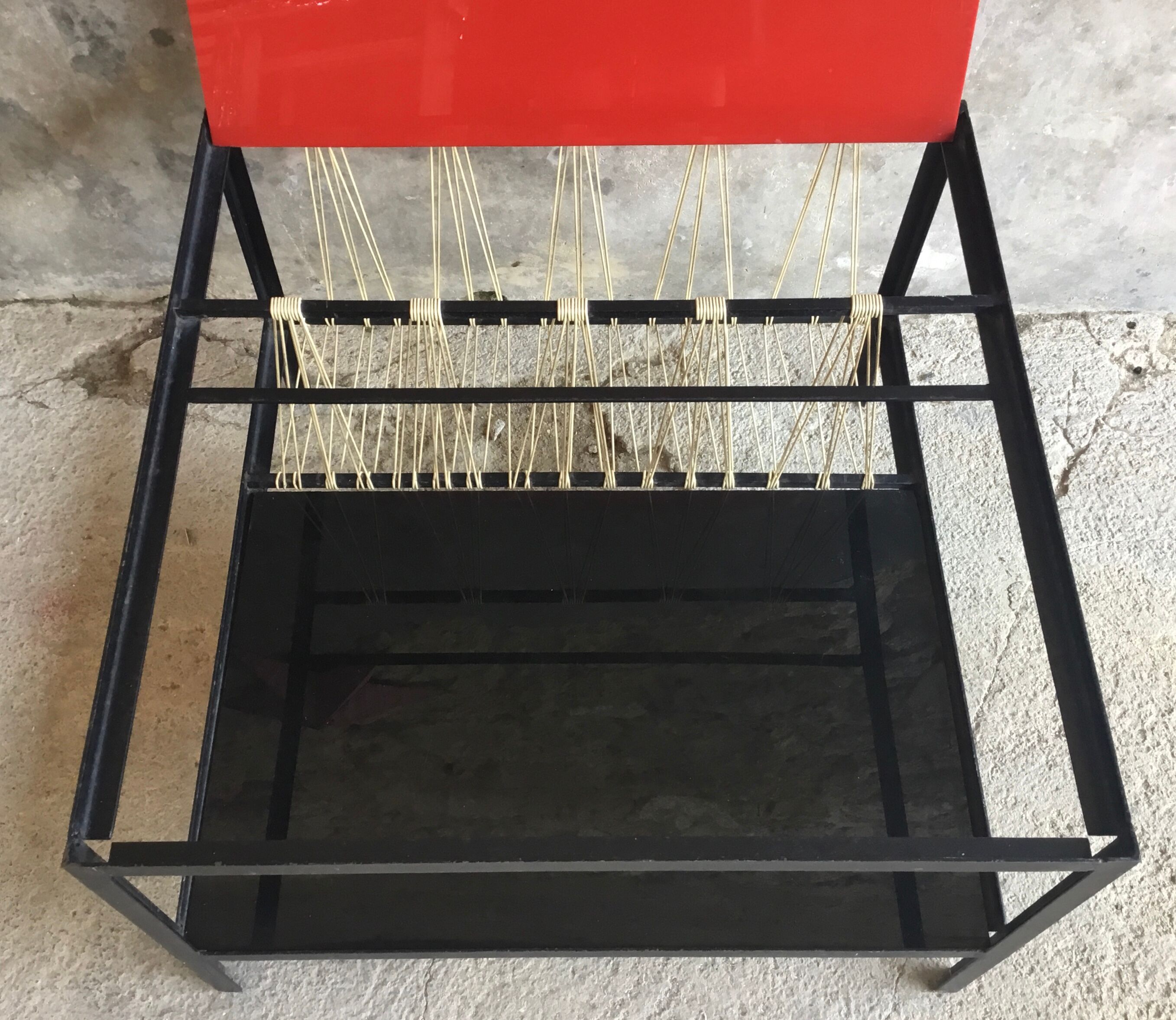 Modernist metal coffee table with a magazine rack in 1950s design.