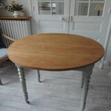 Walnut table with raised flaps, base on verdigris casters.