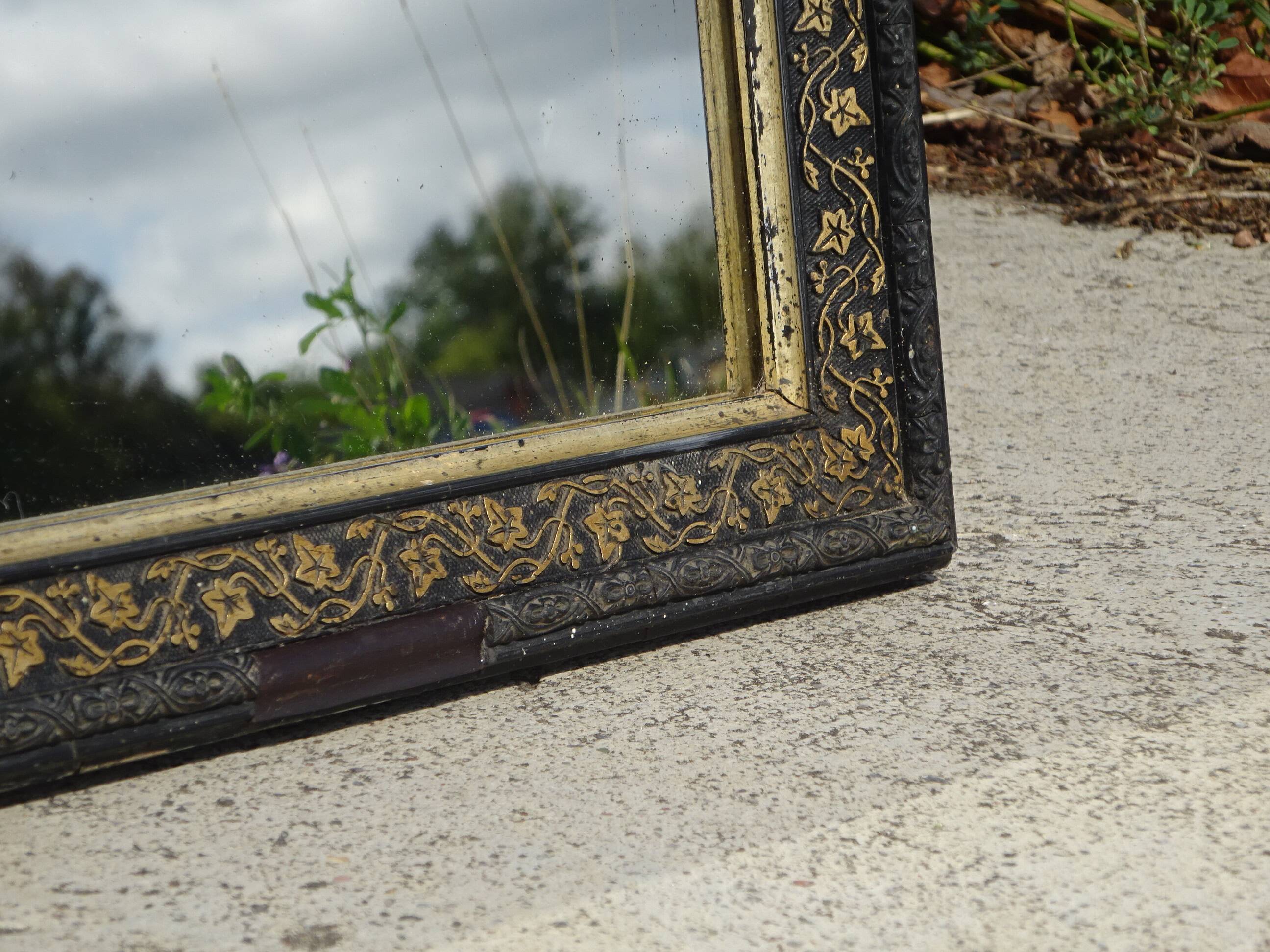 Mirror with black and gold frame, embossed vine leaves