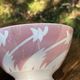 Old footed bowl in earthenware with pink decoration and defects.