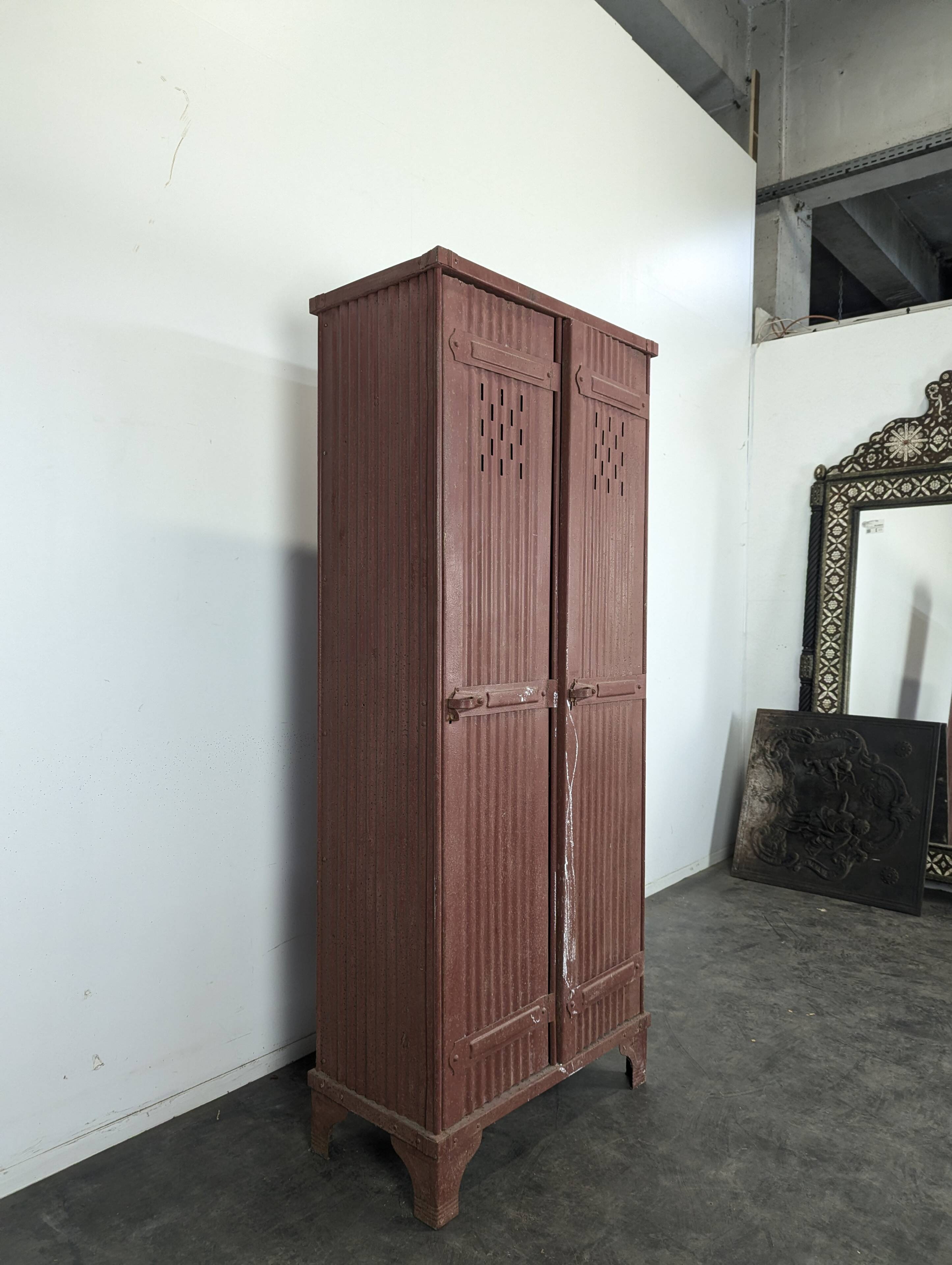 Red painted metal workshop locker with two doors.