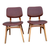 Set of 2 vintage dining chairs with red-brown faux leather upholstery.