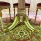 Louis XVI dining room table set with painted wood, gold accents, and pink velvet.