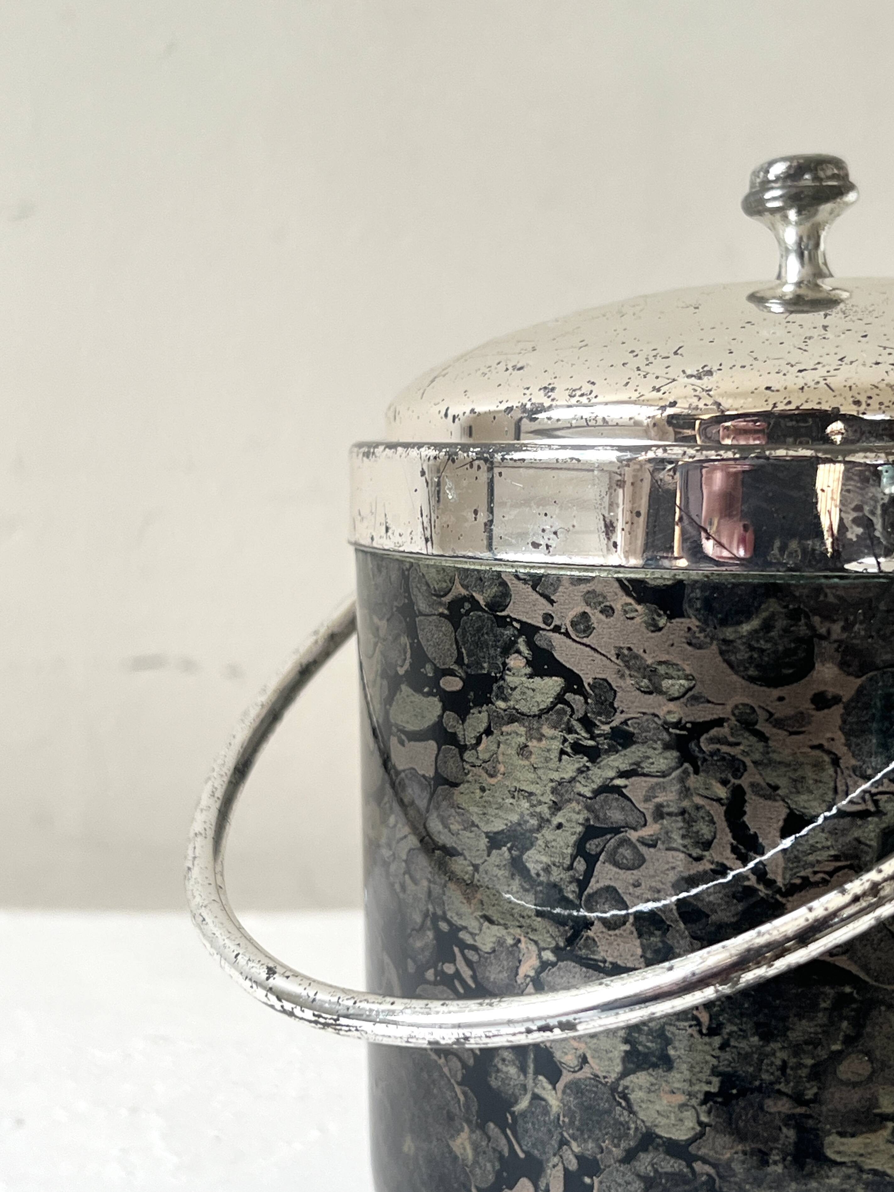 Vintage chrome metal ice bucket with black marbled design, 1970s style.