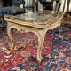 Louis XV style coffee table in carved wood with grey and gold highlights.