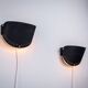 Matte black wall lamps with perforated shades and brass details