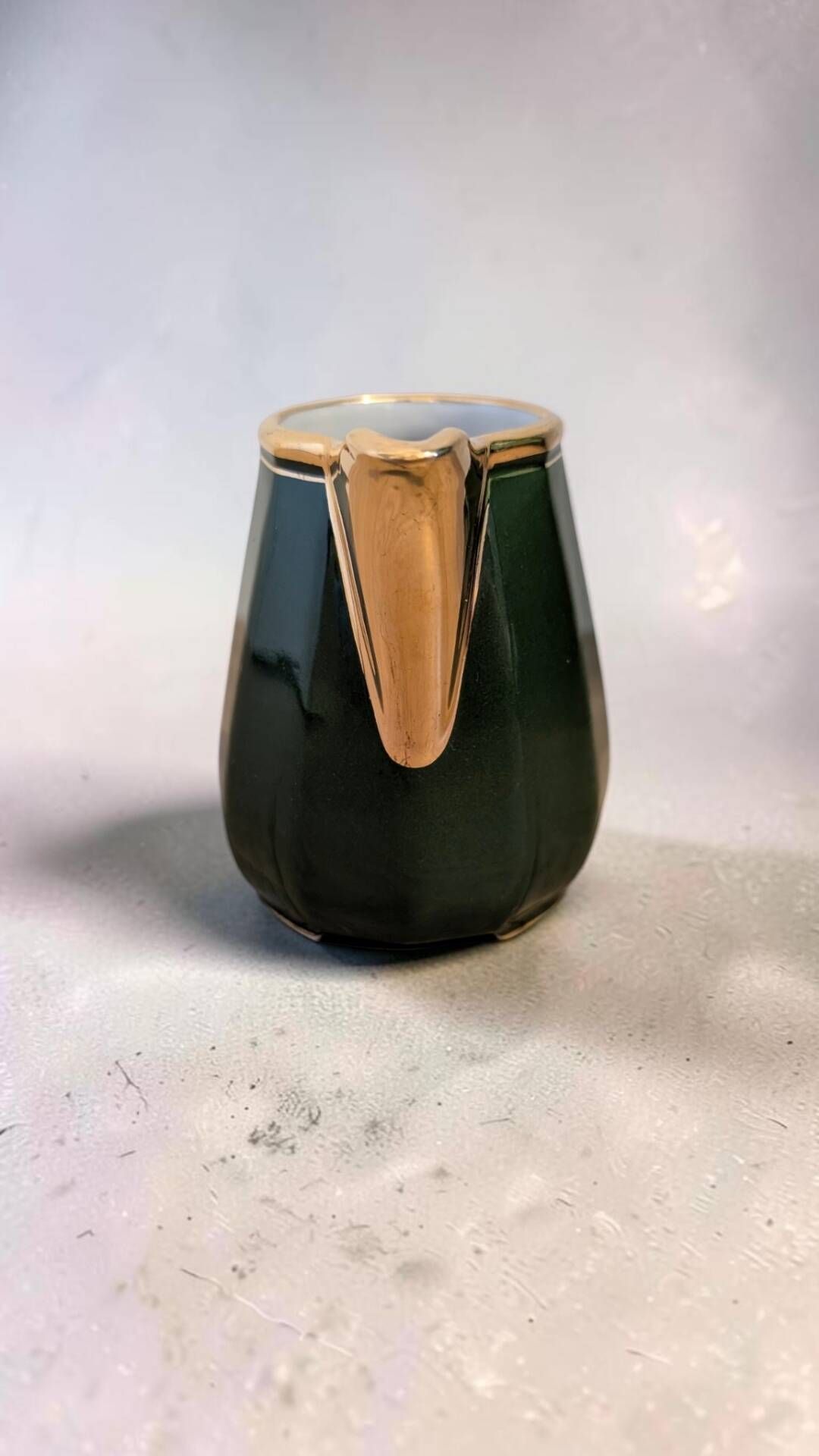 Dark green ceramic decorative jug with golden trim.