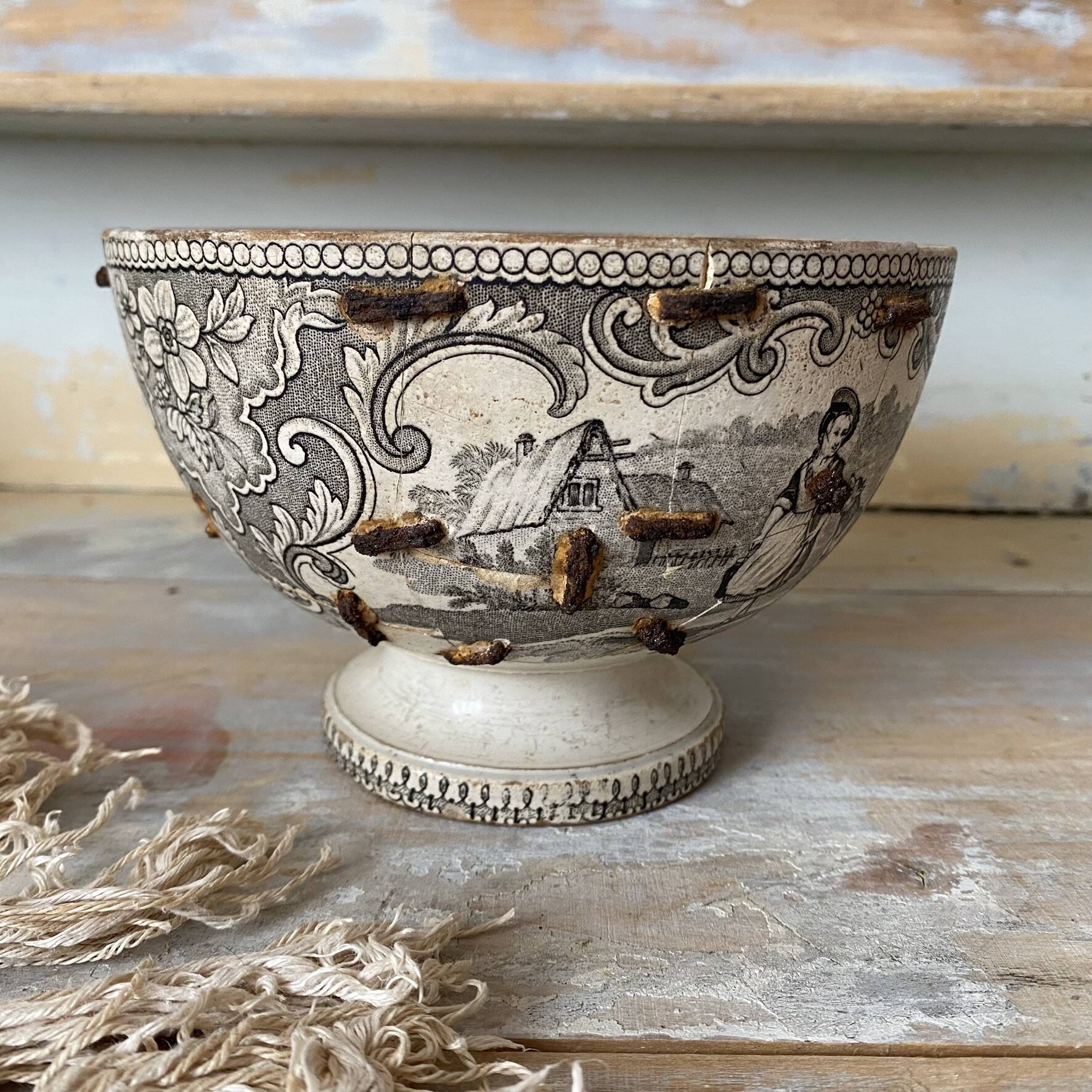 Old bowl made of iron with ceramic seams.