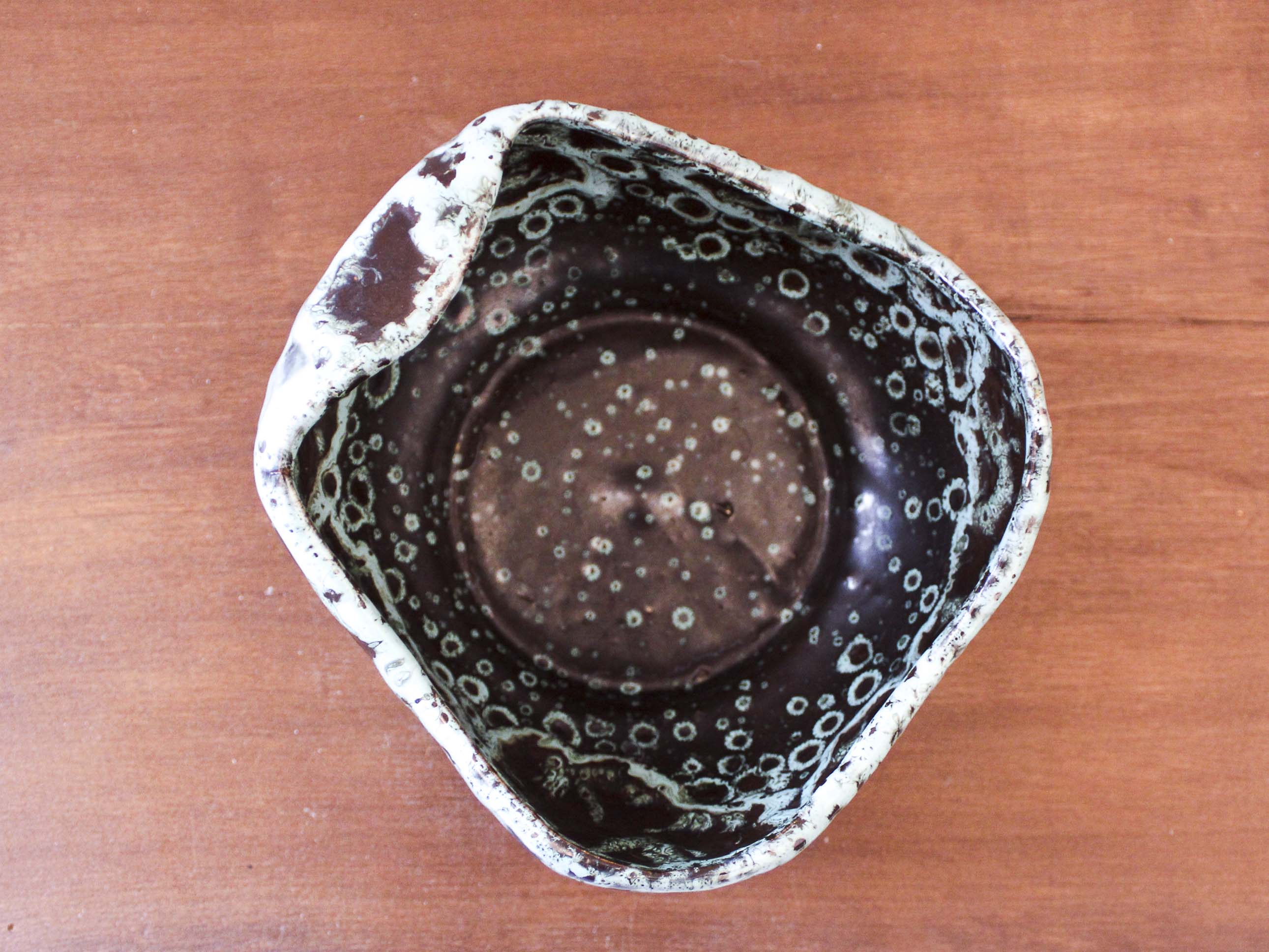 Empty pocket in black ceramic with green drip