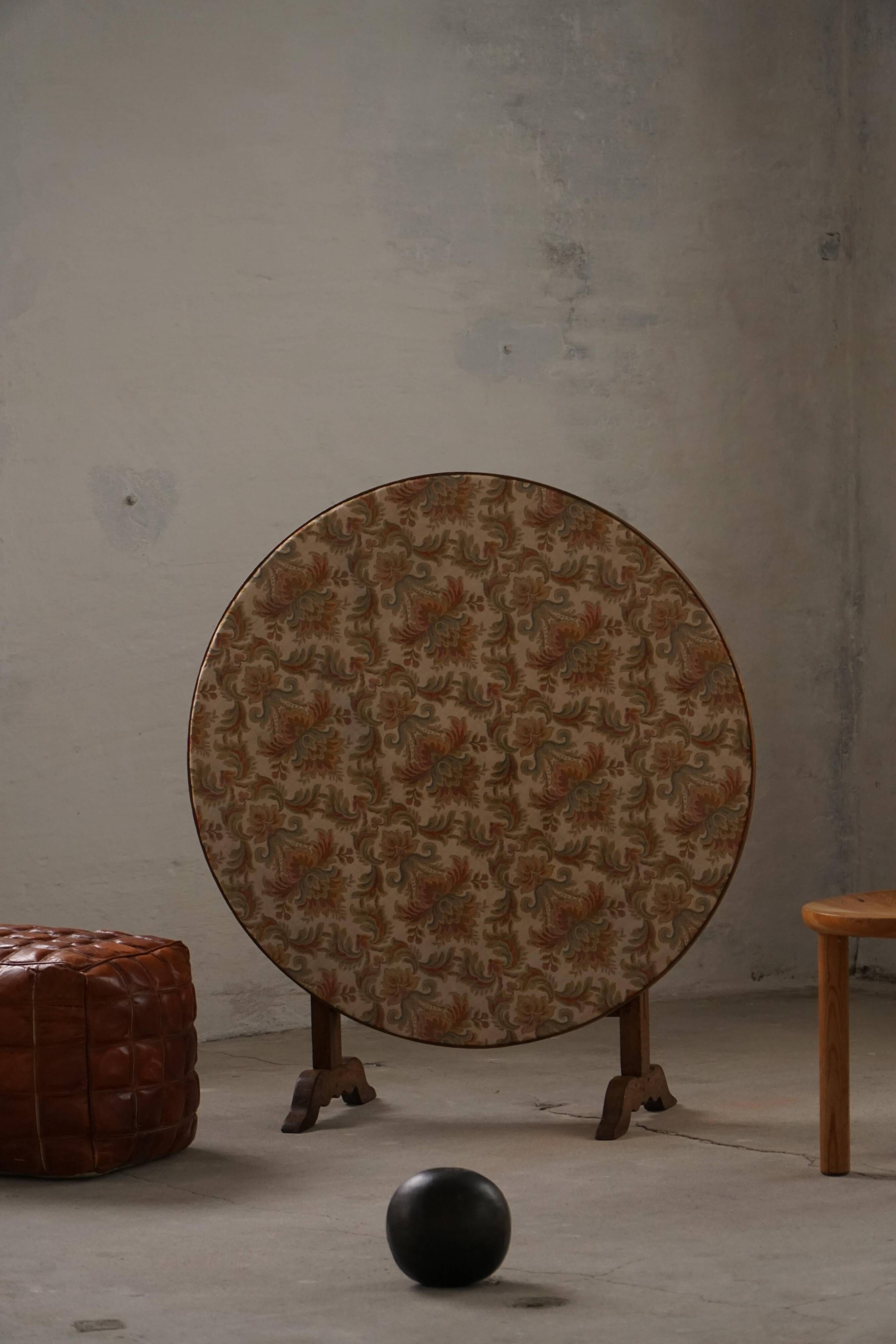19th-century French round wine table with an adjustable top and floral textile surface.