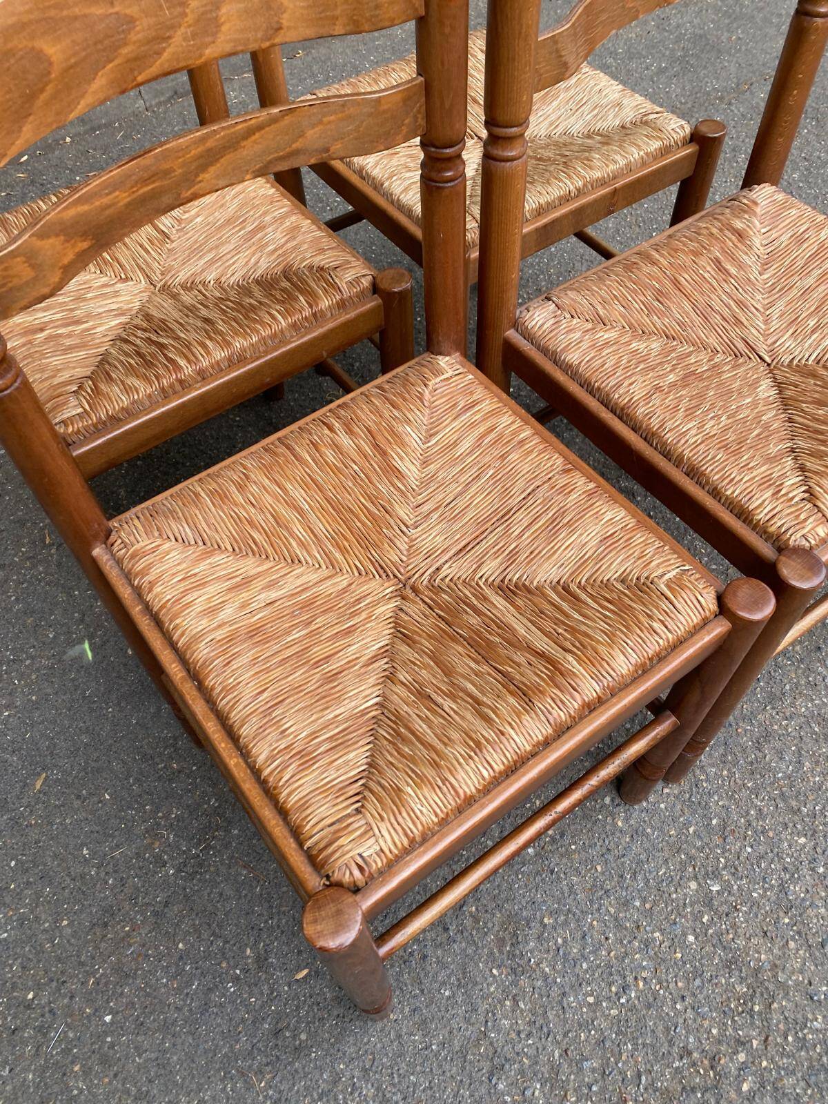4 solid wood kitchen chairs with straw seats in a country farmhouse style.