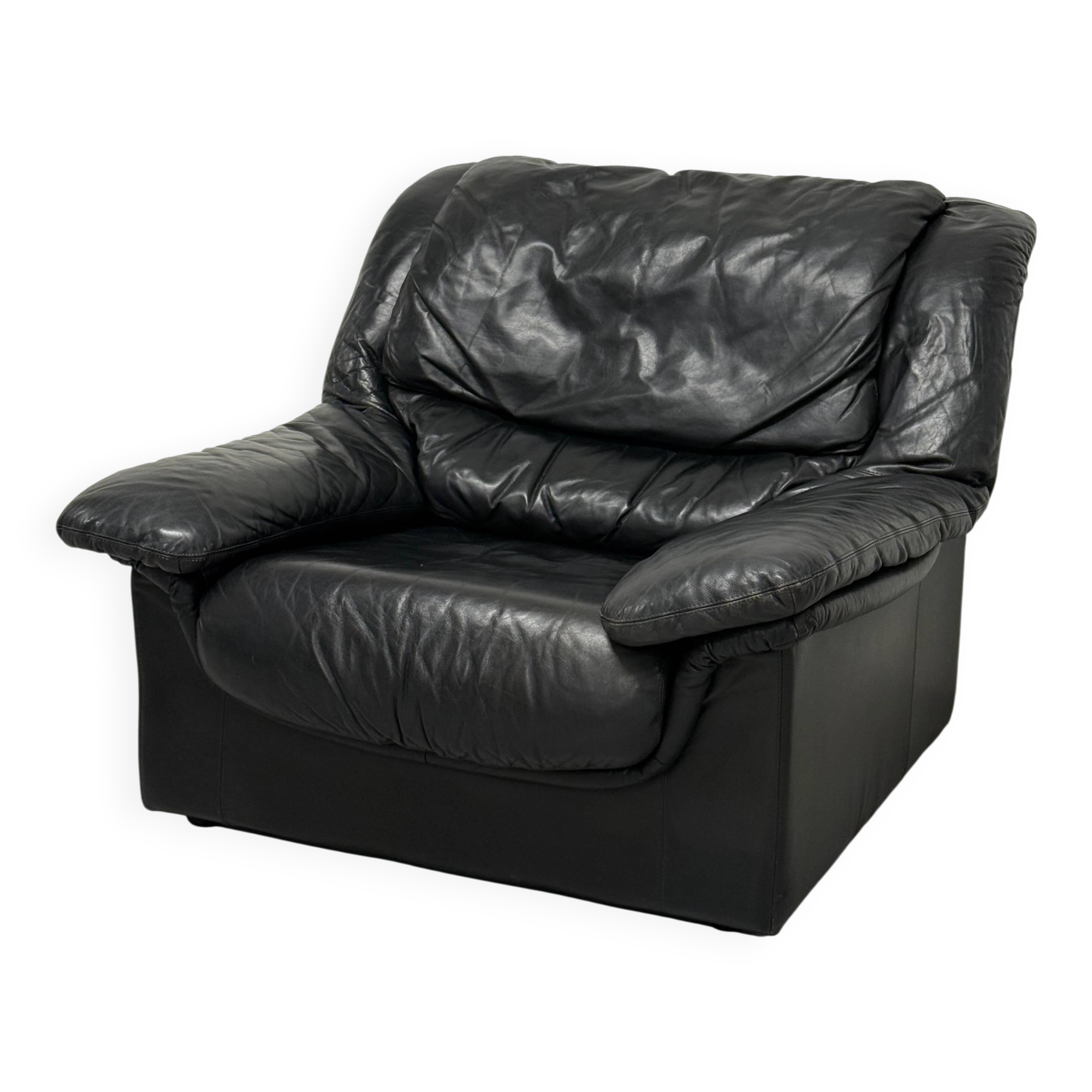 Vintage black leather lounge chair — low postmodern club chair from the space age.