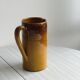 Vintage enameled ceramic watering can vase - retro mustard yellow pot.