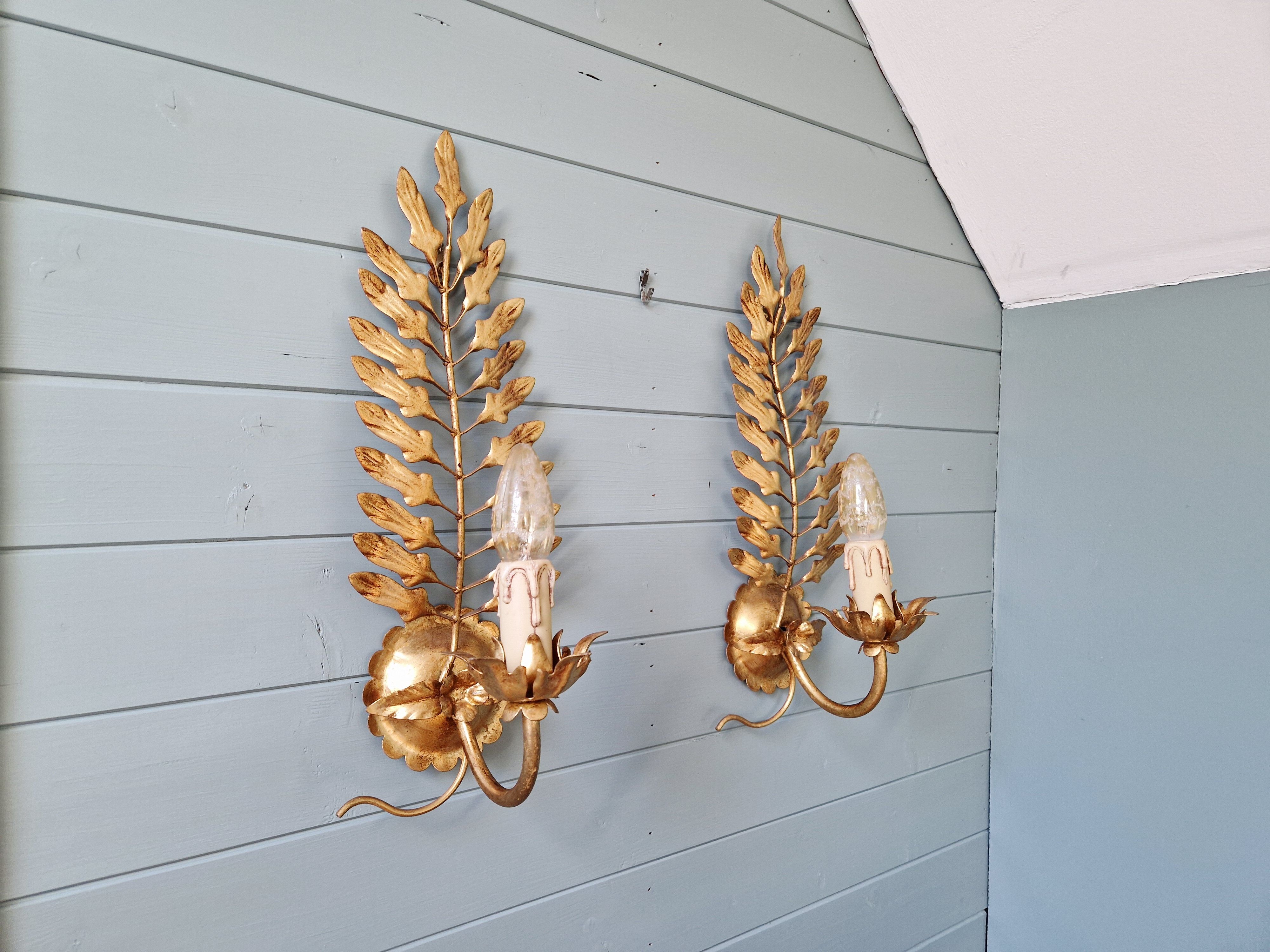 Pair of gold metal wall sconces in Hollywood Regency style, 1970s.