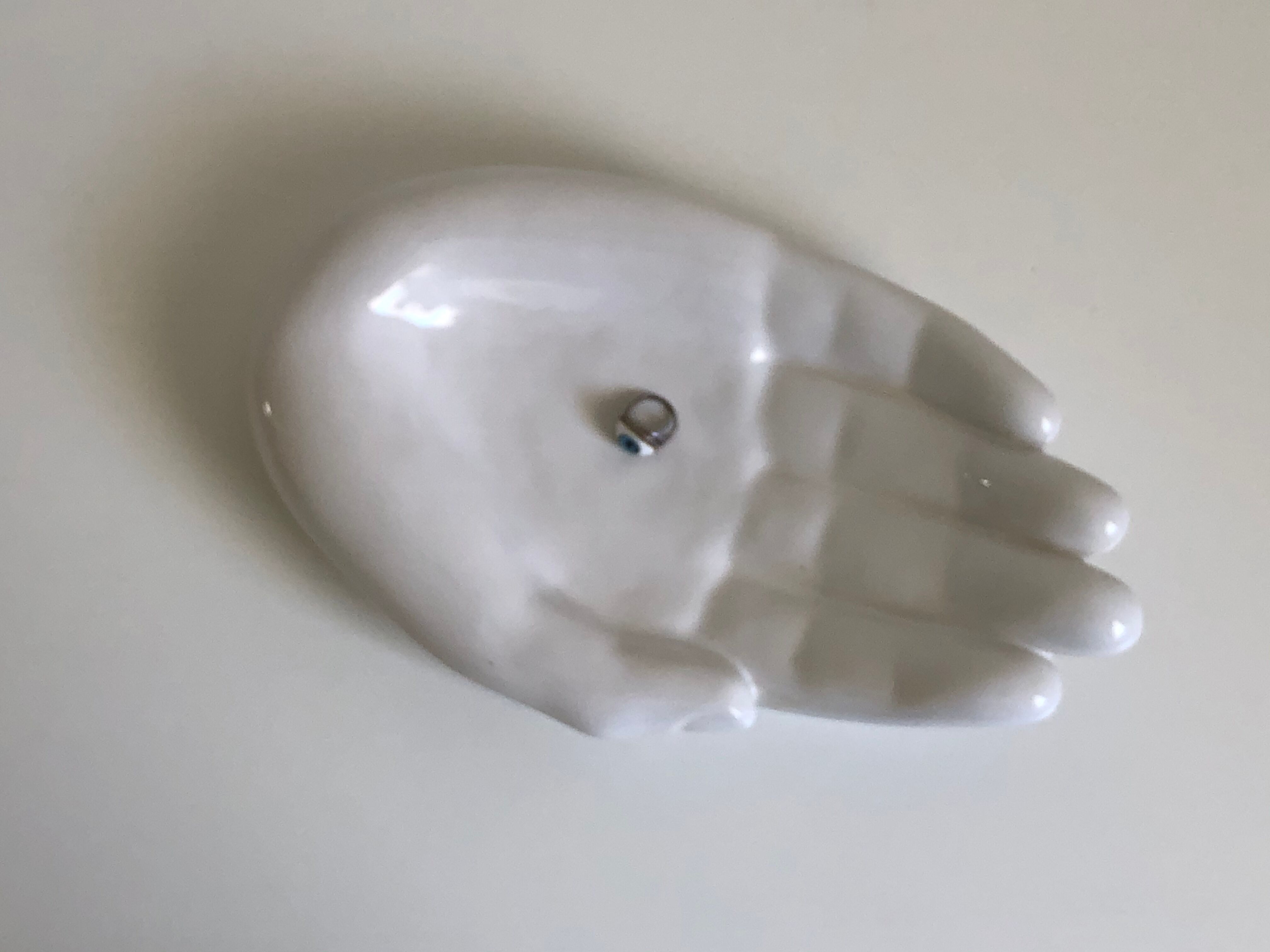 Empty white enamelled ceramic pocket in the shape of a large hand, 1990