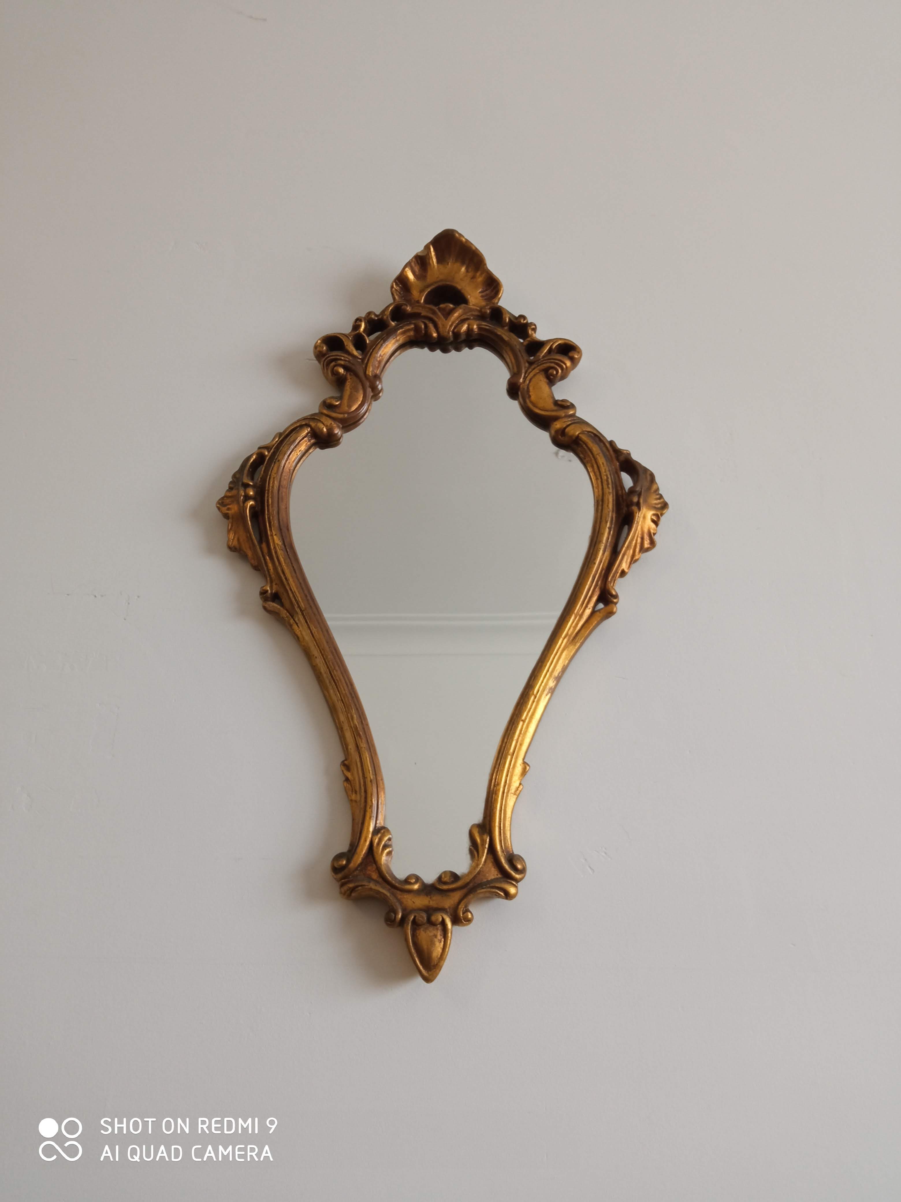 Old wooden mirror and gilded stucco