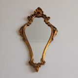 Old wooden mirror and gilded stucco