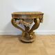 A round Louis XV style table in carved gilt beechwood with a black marble top