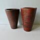 Pair of red enamelled terracotta vases, signed
