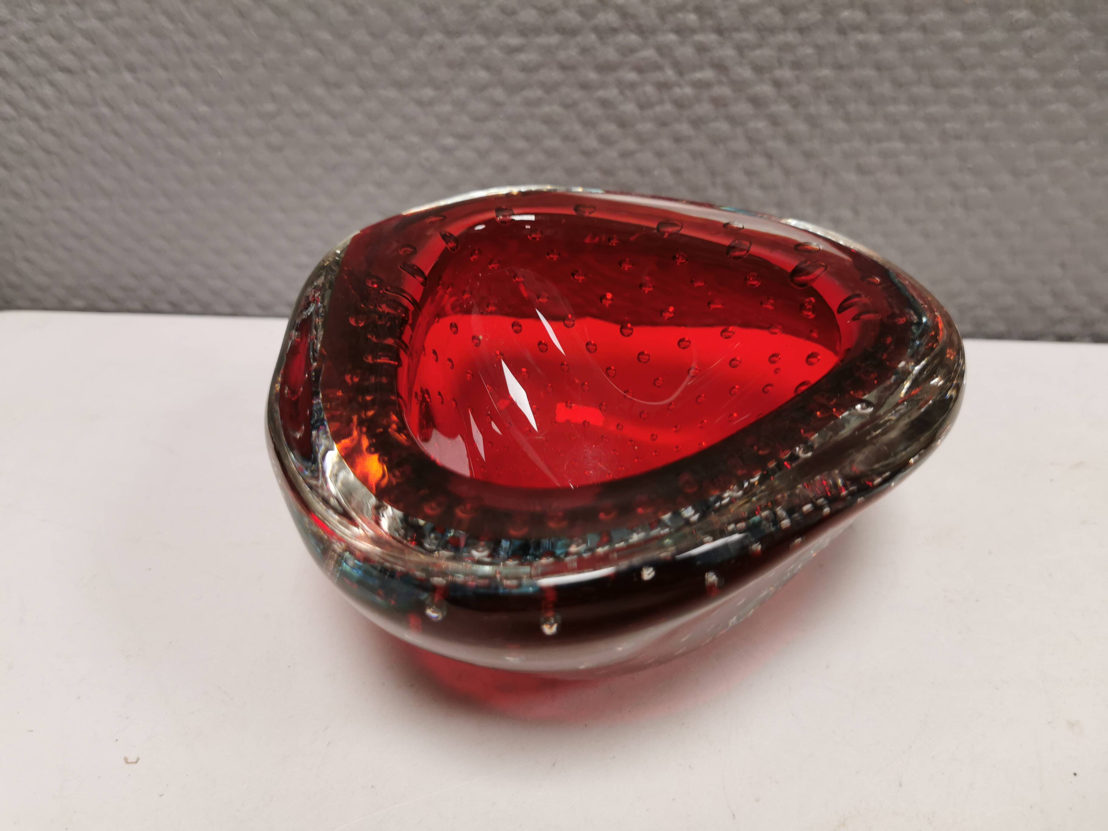 Small glass bowl in beautiful emerald red color with inlaid bubbles.