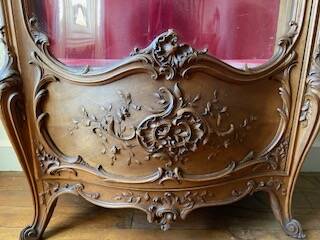 Large wooden display cabinet in Louis XV/rococo style with a strongly curved front.