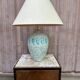 Vintage green ceramic table lamp with a worn lampshade.