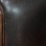 Dark brown vintage club armchair in English style made of sheepskin leather