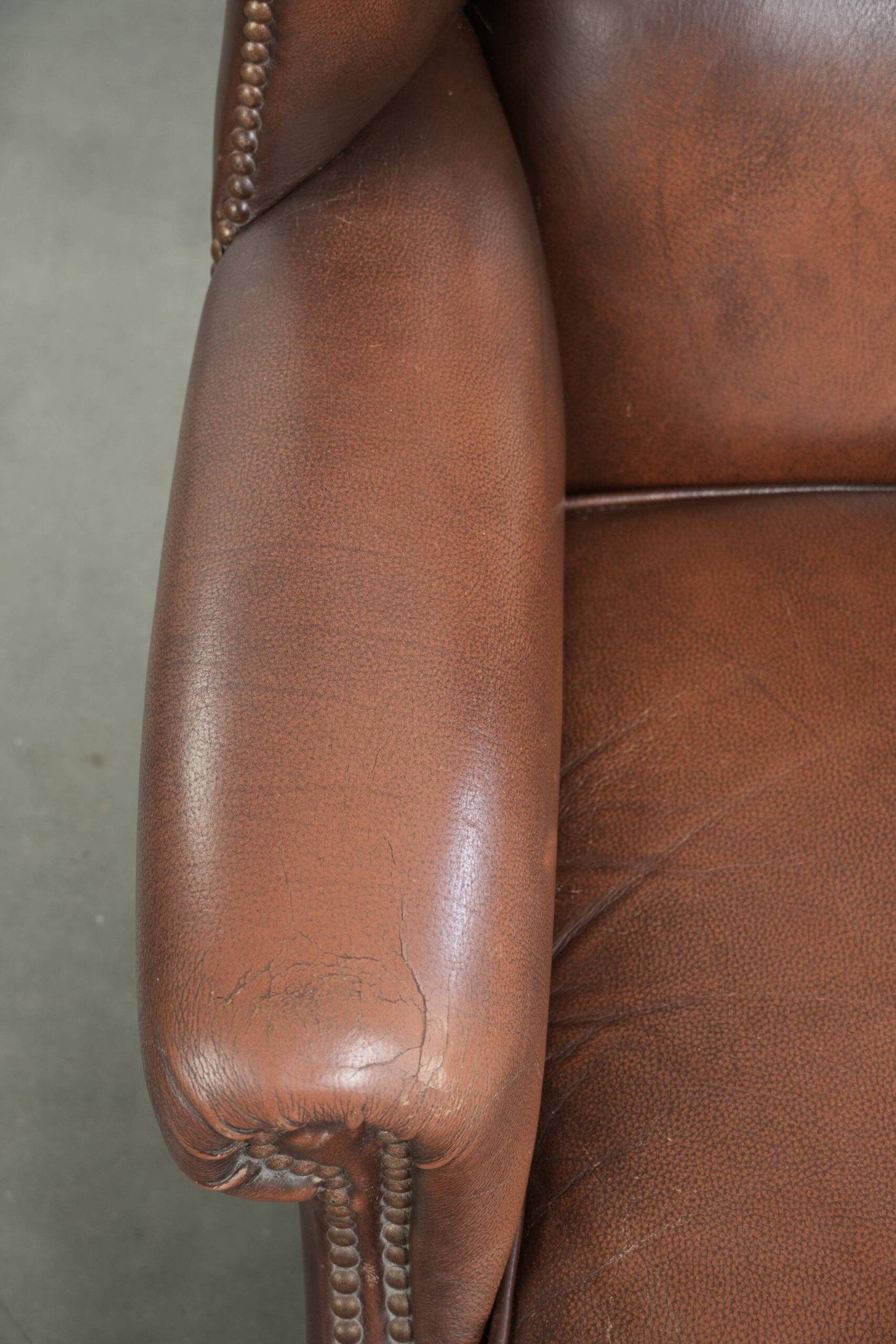Fauteuil à oreilles en cuir de vache confortable de style anglais avec un look intemporel.
