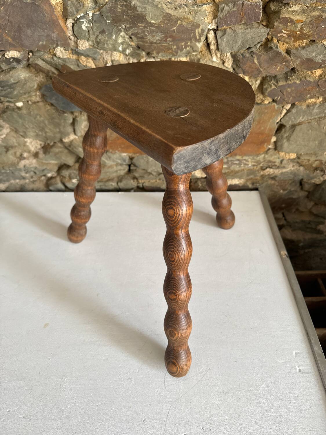Low tripod stool with turned legs