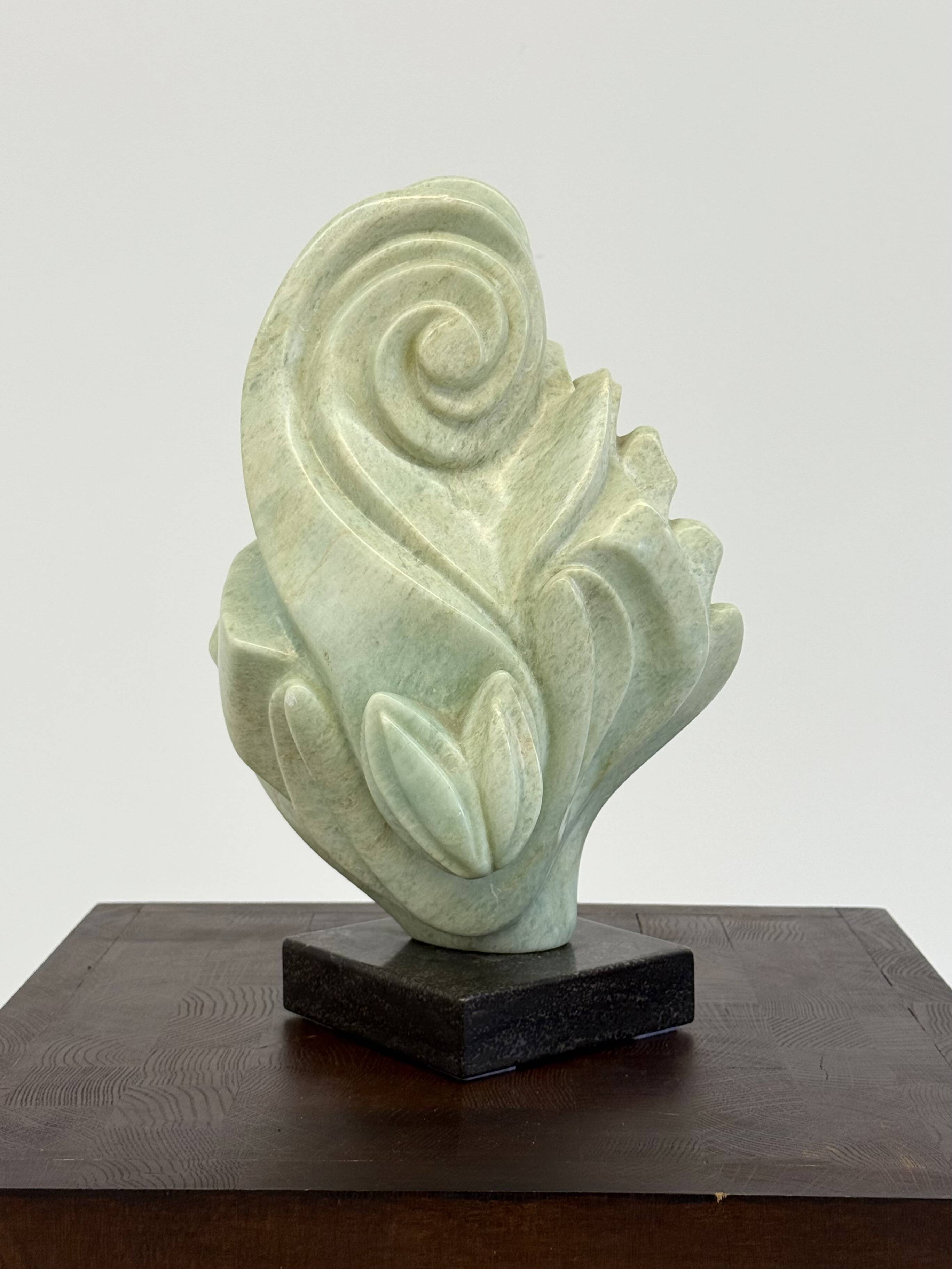 Green natural stone sculpture on marble base