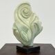 Green natural stone sculpture on marble base