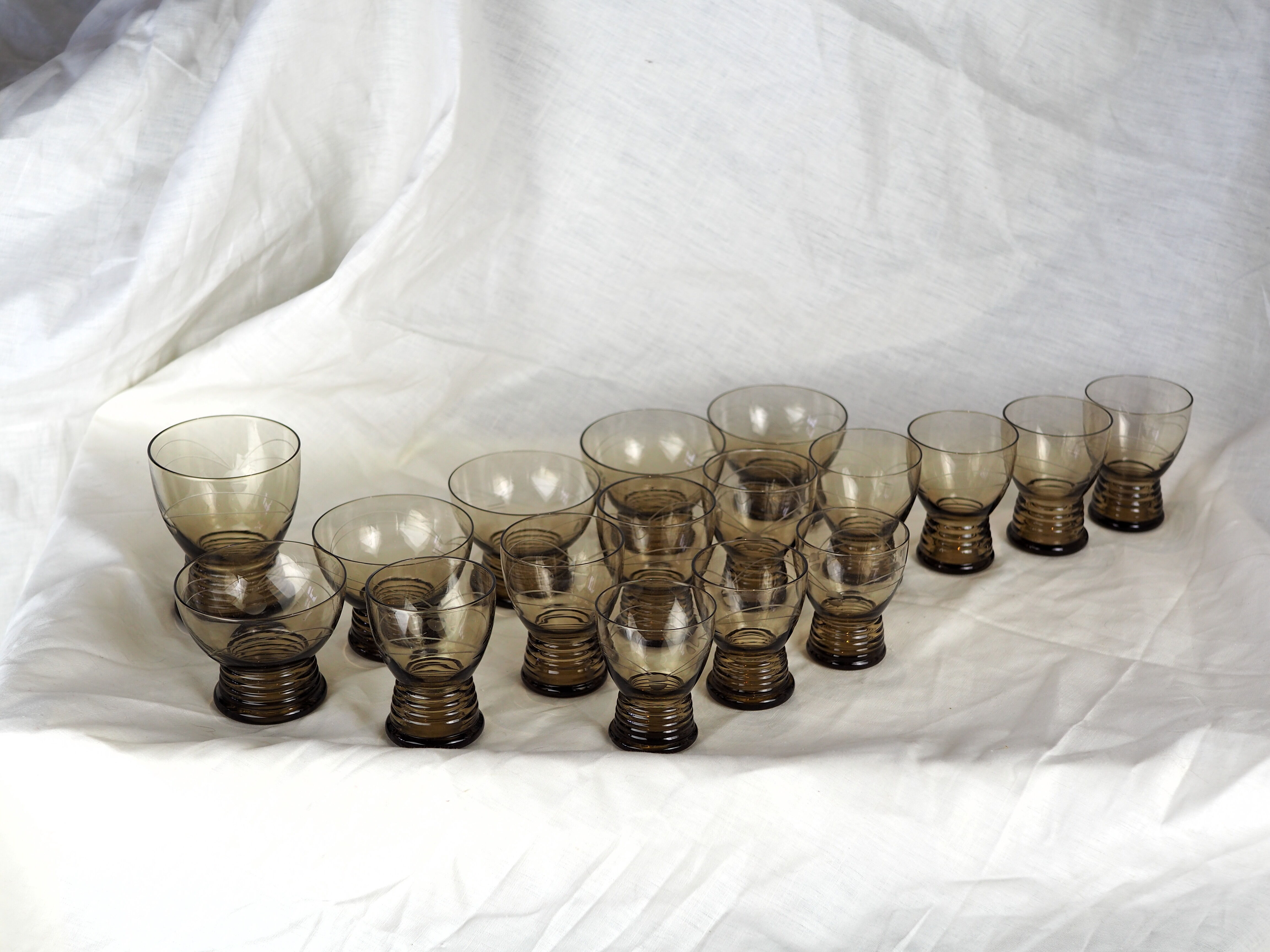 Set of 17 black smoked glasses on geometric engraving stand - 70s