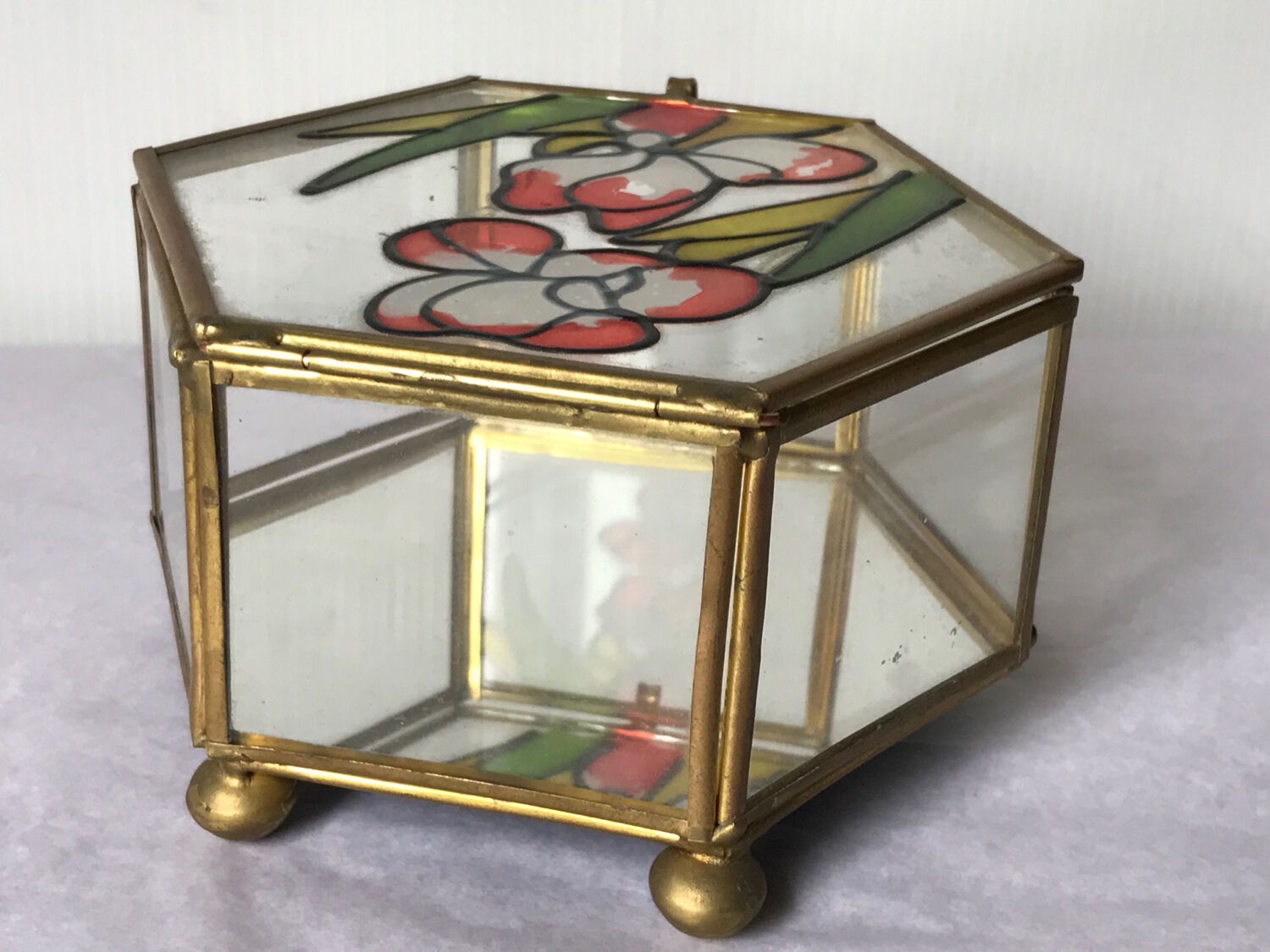 Glass box and hexagonal brass enamelled floral decoration