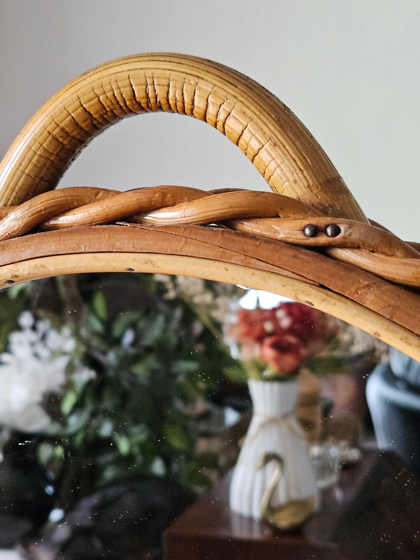 Vintage double-sided round mirror on a rattan stand.
