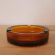 Vintage Italian round ashtray in thick amber glass – Ø 15 cm