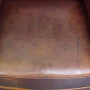 Very comfortable classic cowhide armchair with a high back in a mild Art Deco style