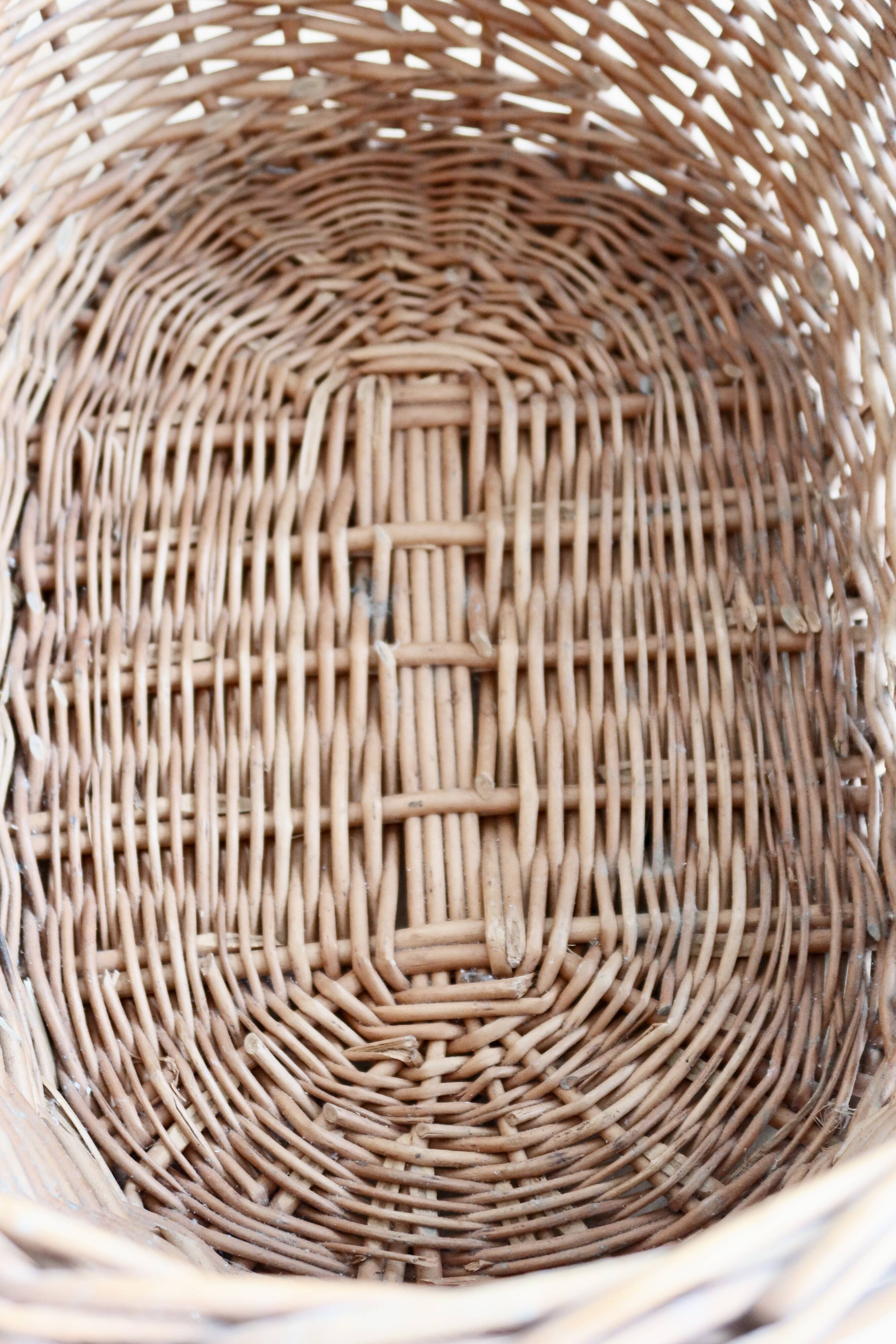 Large vintage woven wicker basket with a central handle.