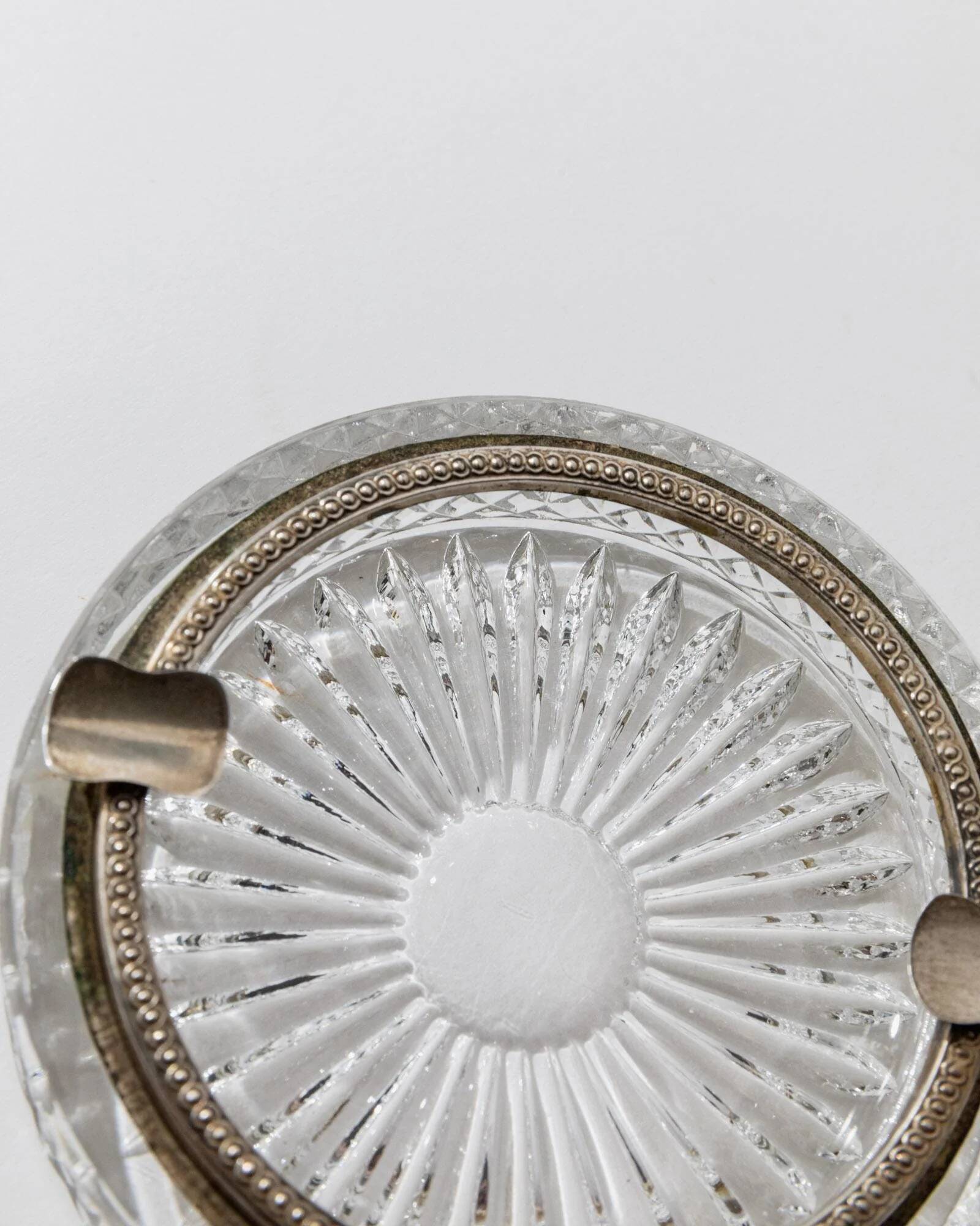 Vintage crystal glass ashtray from the 1920s, silver-edged with a textured pattern, Art Deco table decoration.