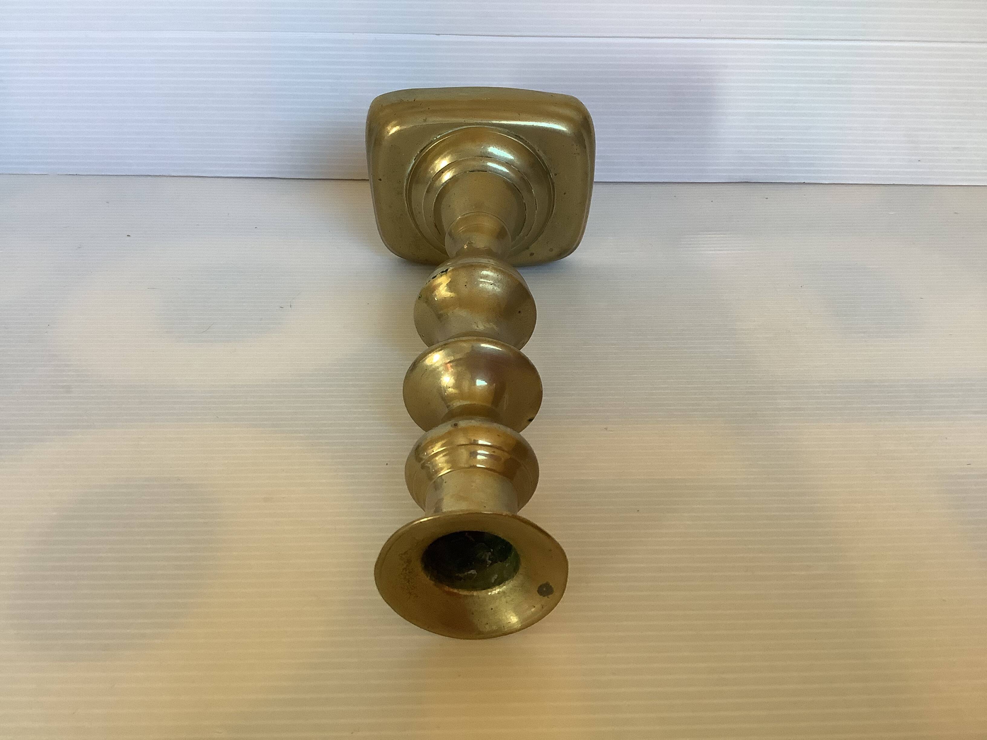 Brass candlestick with a rectangular base.