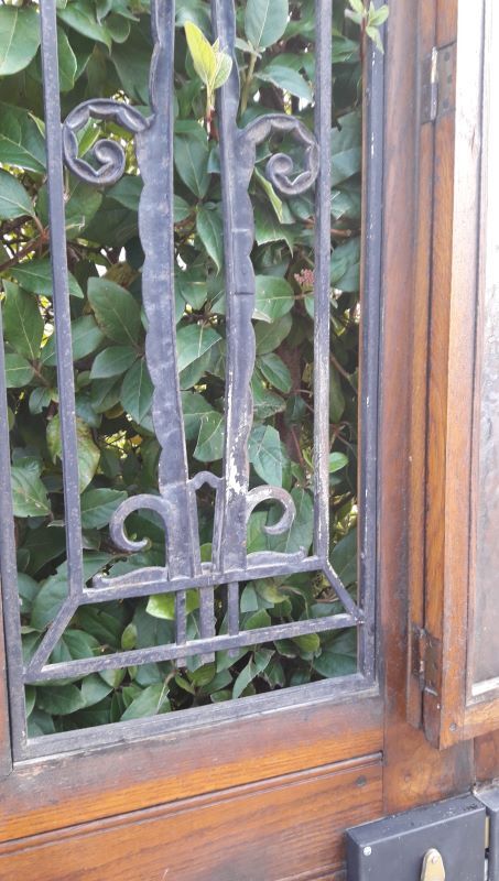 Oak entrance door and its frame and transom, wrought iron gates