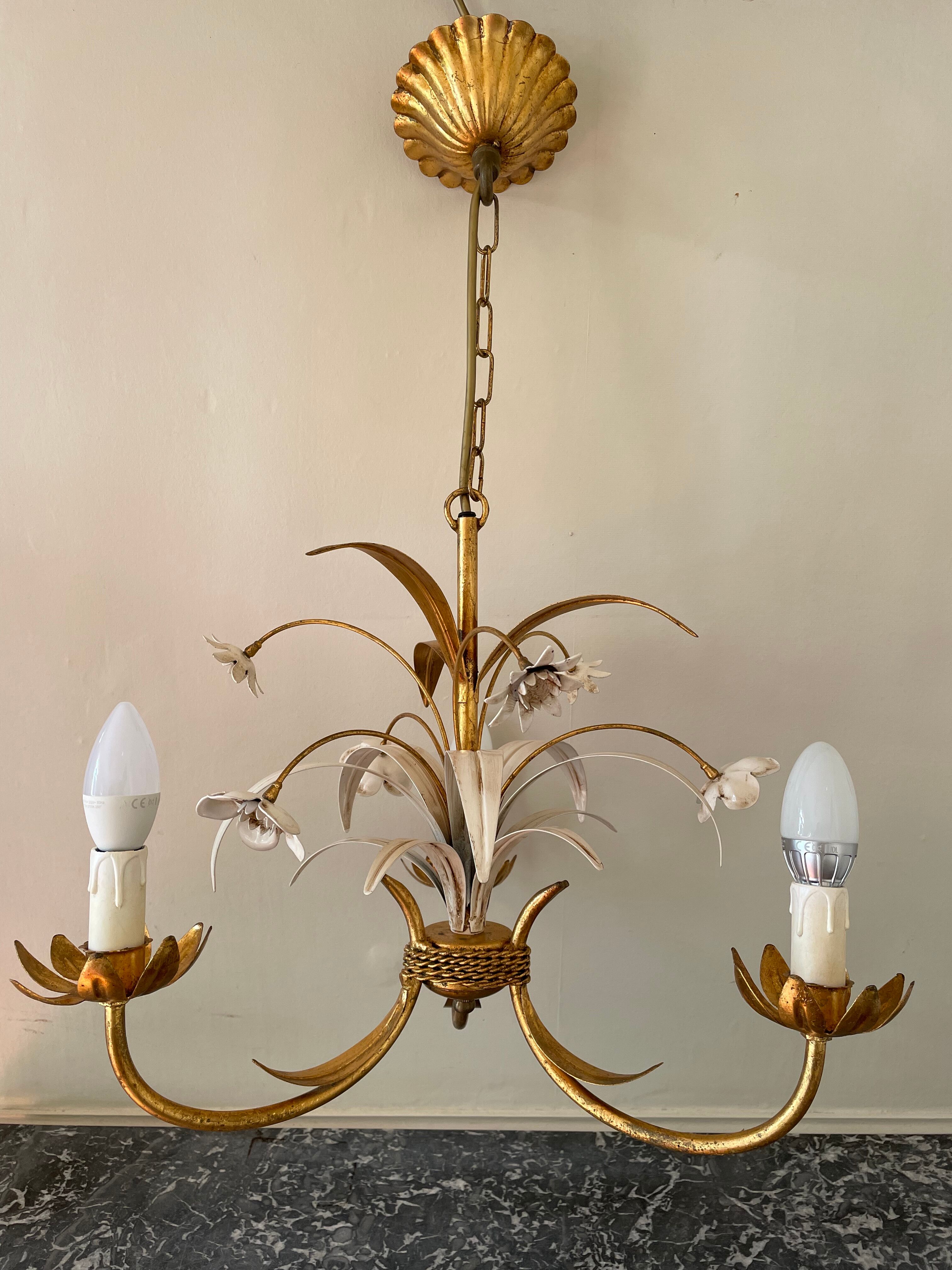 Golden metal chandelier decorated with flowers