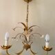 Golden metal chandelier decorated with flowers