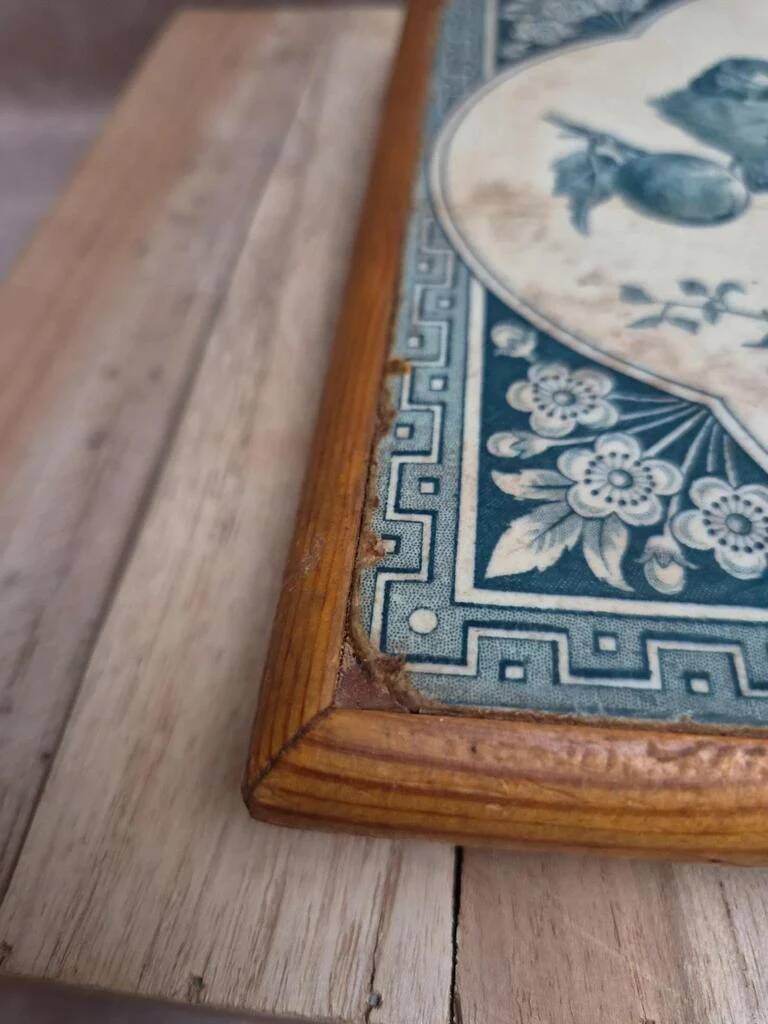 Antique trivet in Gien tile with blue bird decoration – wooden border