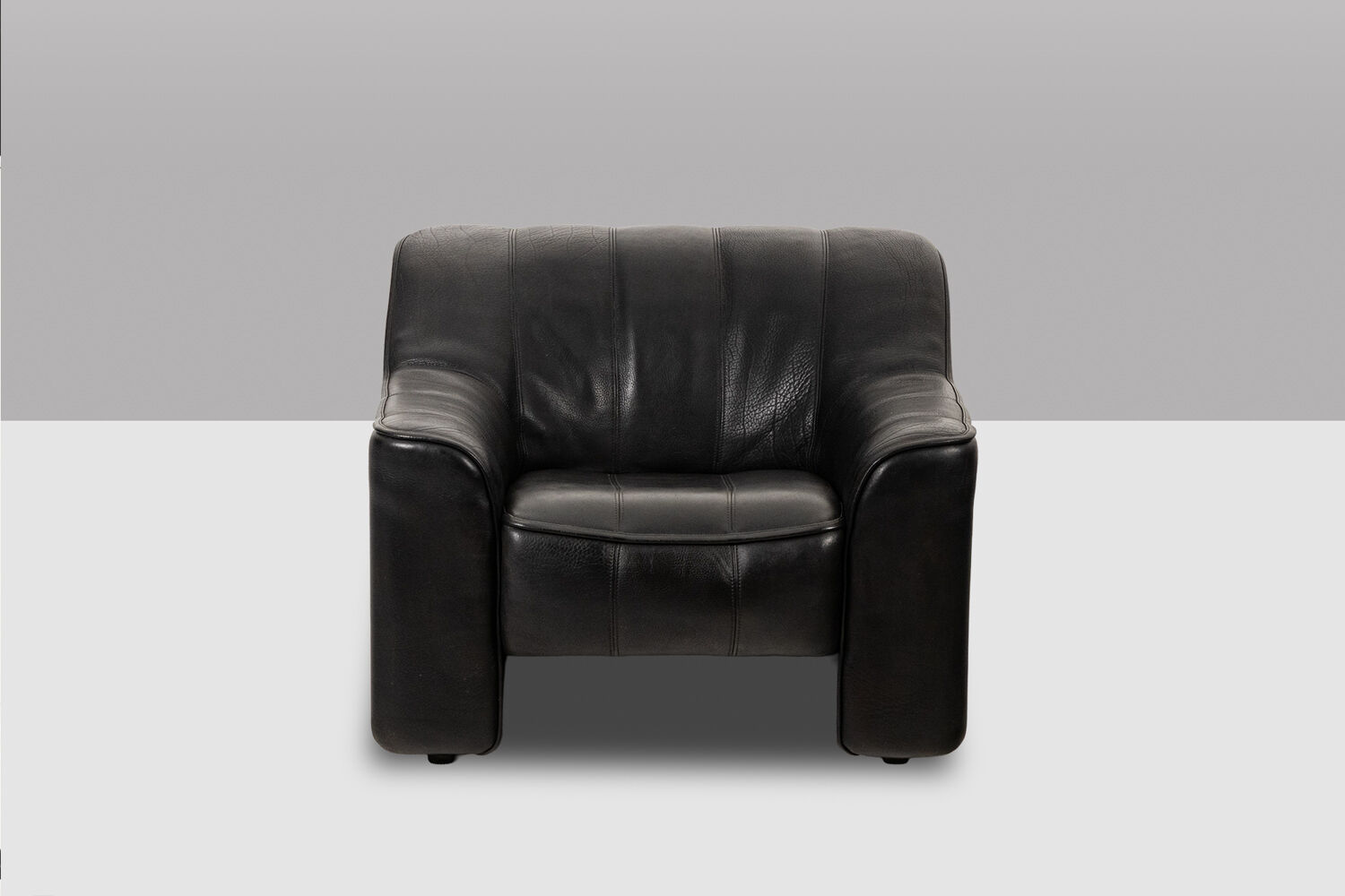 Maison De Sede. Armchair and its ottoman in black leather. 1970s.