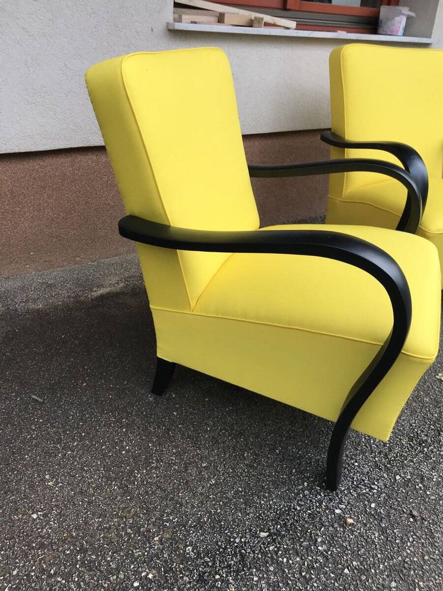 Pair of yellow Art Deco armchairs in cotton and wood, black frame, 1920s.