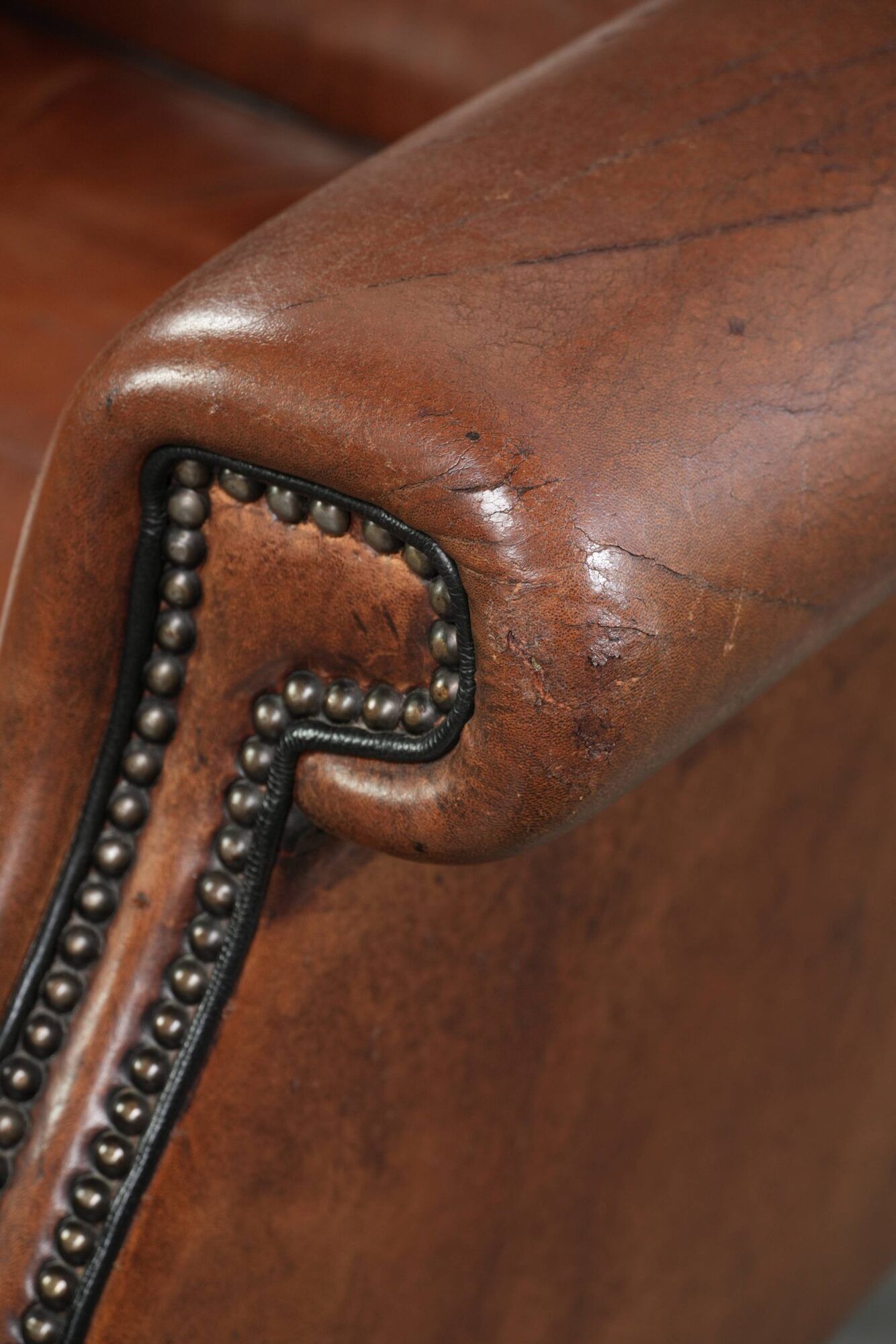 Sheepskin wingback armchair finished with black piping and a correct seat