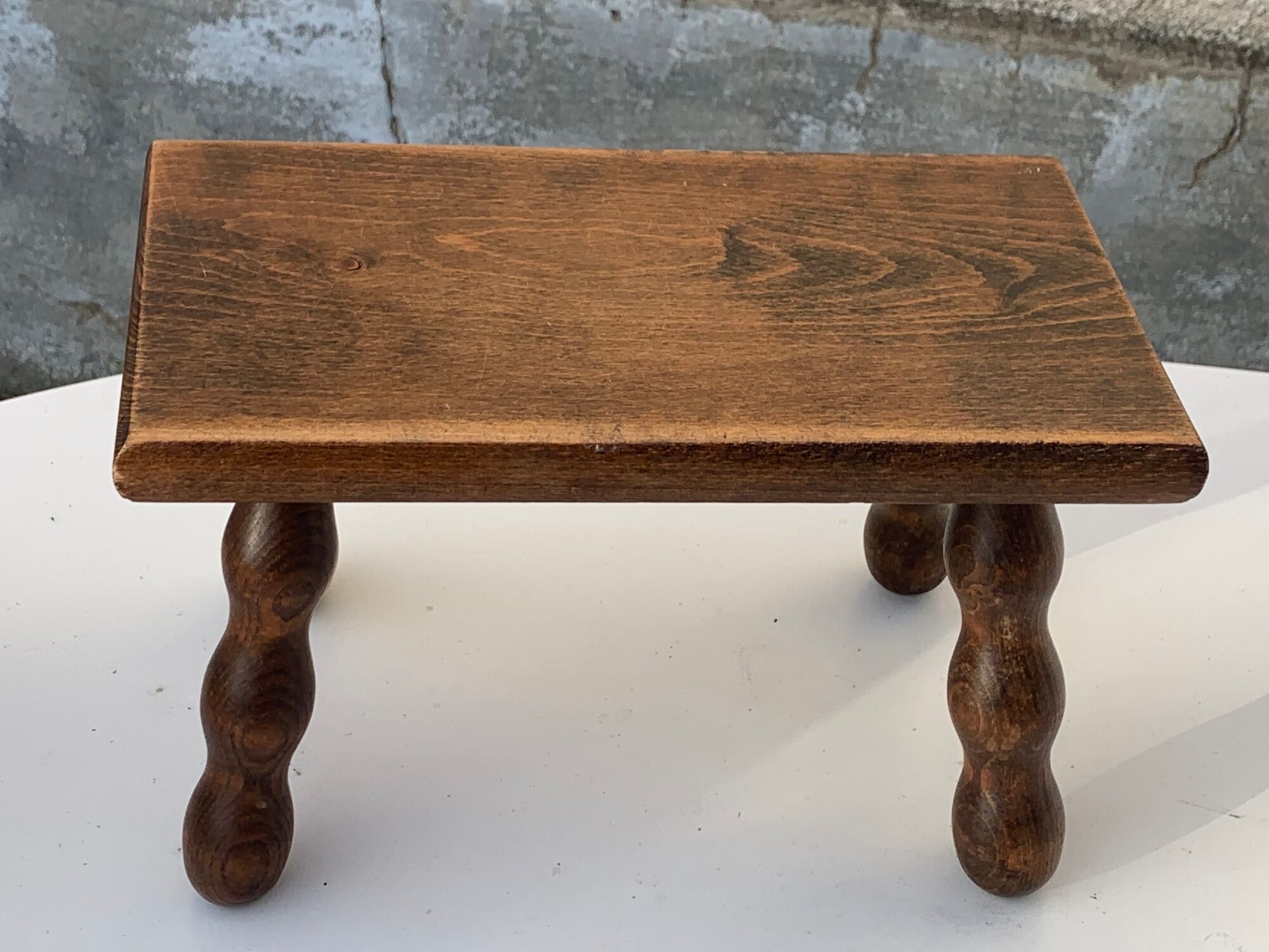 Footstool in varnished wood turns old