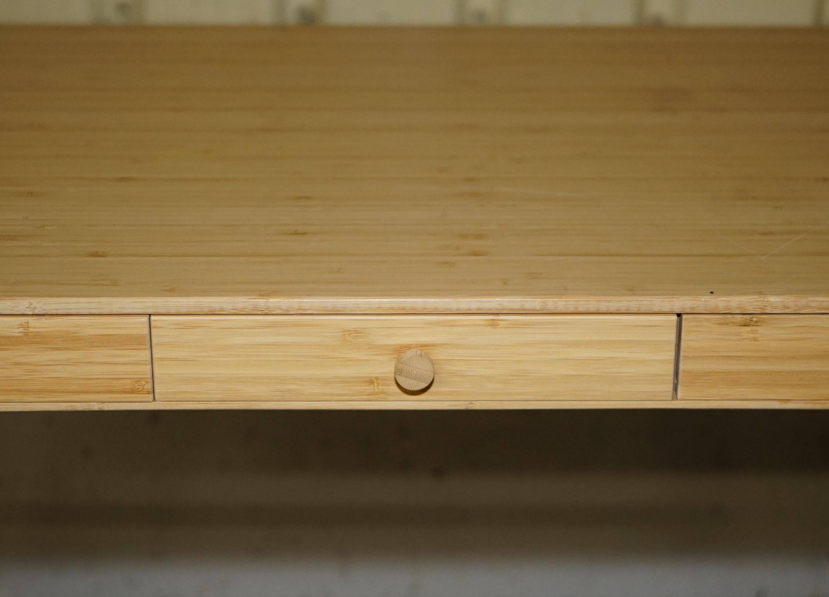 Small bamboo desk with three drawers.